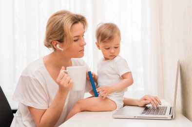 A Nanny and a Toddler Looking at a Laptop