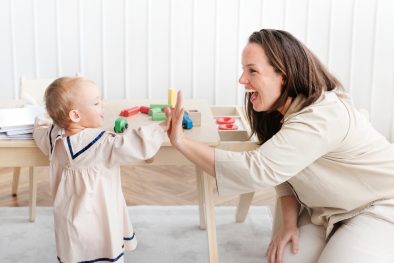 A nanny and a Toddler high-fiving